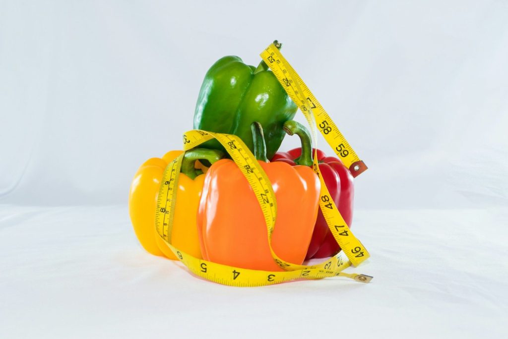 a measuring tape wrapped around peppers and peppers